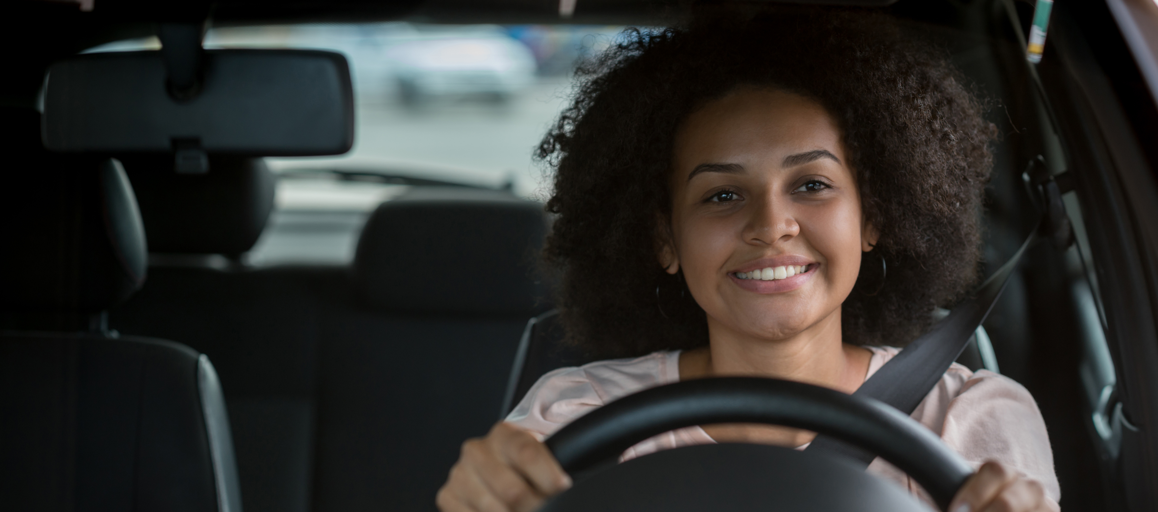 Smiling woman driving a car.